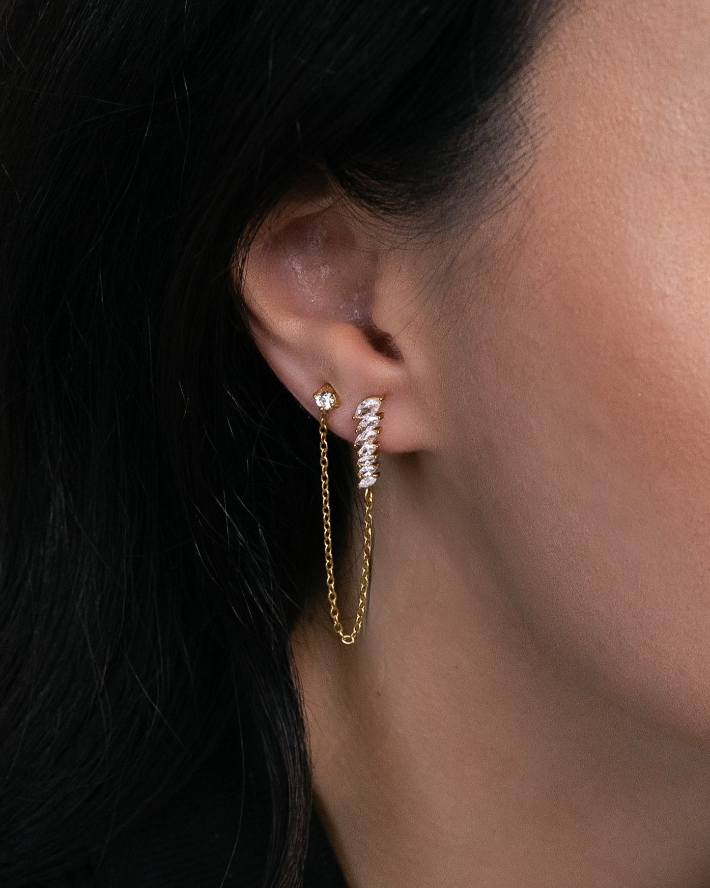 Обеца Kaya Chain с цирконии, свързана с нежна златна верижка, изработена от медицинска стомана с 18к златно покритие.